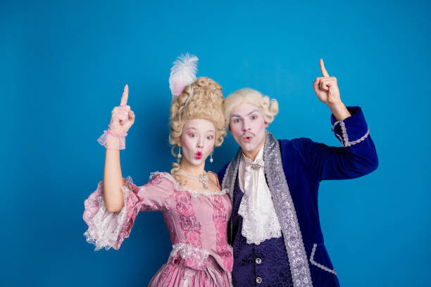 istock Elegant couple posing joyfully against a vibrant blue background, showcasing a whimsical blend of historical and modern styles 2193998078