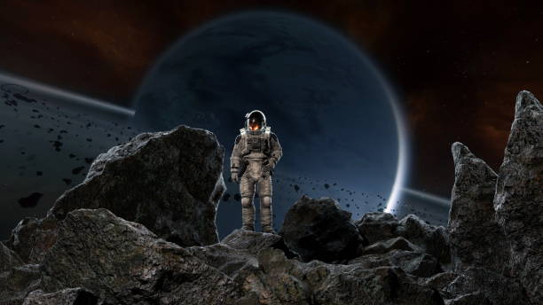 istock Astronaut stands on a rugged landscape filled with dark rocks on an unfamiliar exoplanet. 3d render 2194003313