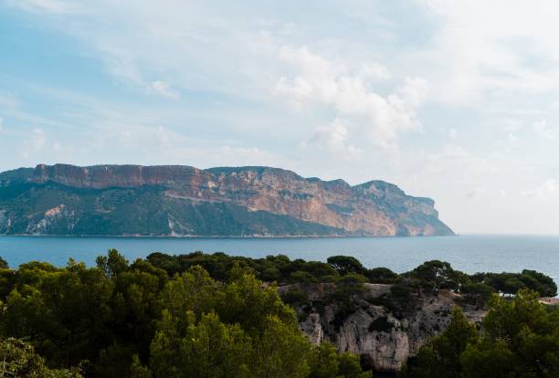 istock Rocky coastline with lush greenery and calm sea. 2194003720