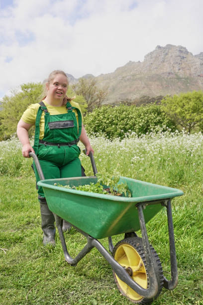 istock Female farmer pushing wheelbarrow in garden 2194004225