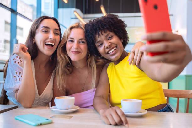 istock Three happy Friends Taking a Selfie While Enjoying Coffee in a Modern Cafe 2194004240