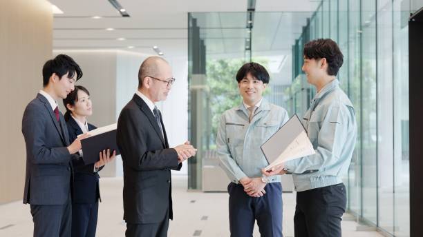 istock A businessman and a man in work clothes talking in the lobby 2194005571