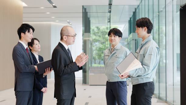 istock A businessman and a man in work clothes talking in the lobby 2194005576