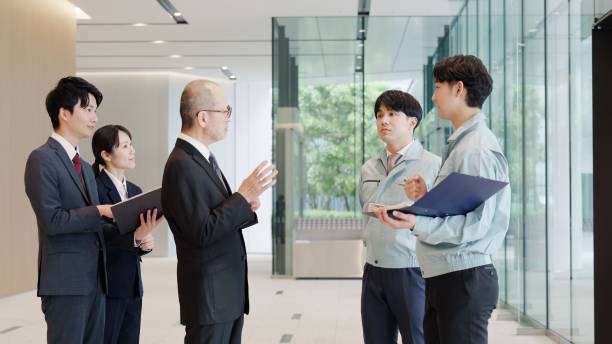 istock A businessman and a man in work clothes talking in the lobby 2194005624
