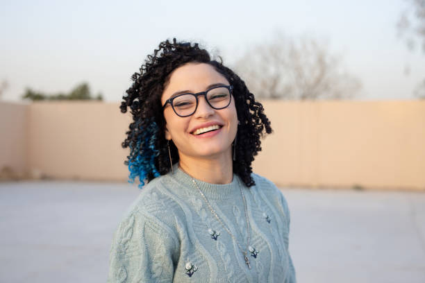 istock Confident young woman with curly hair smiling outside 2194007536