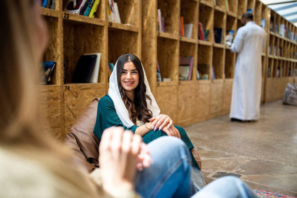 istock Saudi woman talking with a friend sitting at library 2194007543