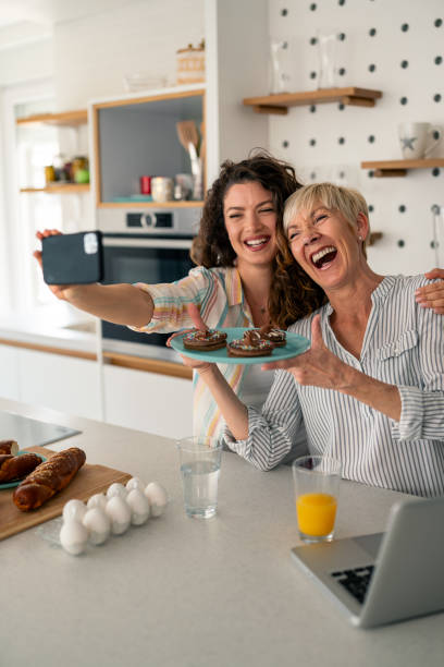 istock Joyful Caucasian Mother and Daughter Taking Selfie in Modern Kitchen 2194013456