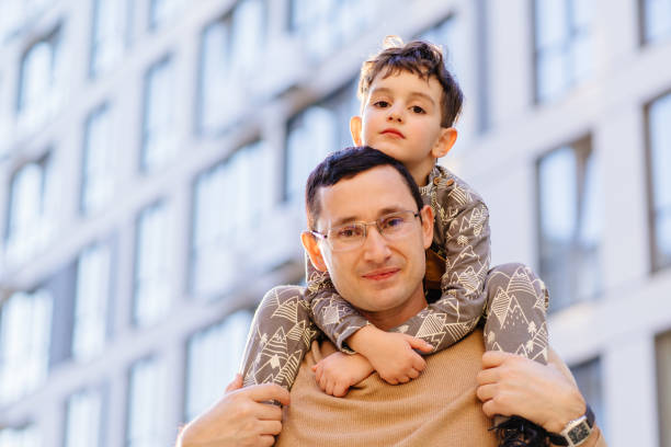istock Father and little son bonding outdoors in urban cityscape setting 2194014342