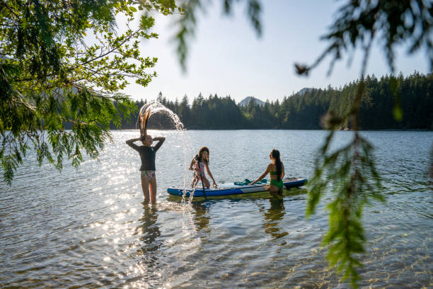 istock Mother and daughters enjoy SUP board on mountain lake 2194015937