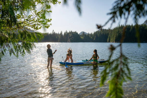 istock Mother and daughters enjoy SUP board on mountain lake 2194015954