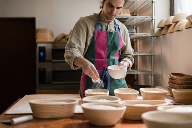 istock Baker sprinkling flour into bannetons for sourdough bread baking 2194018389