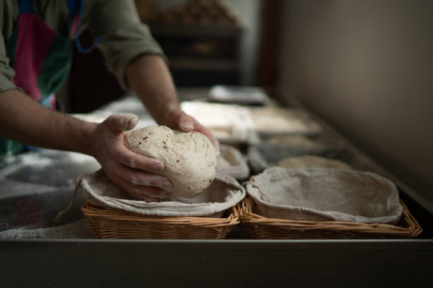istock Baker placing dough in basket for rising in bakery 2194018405