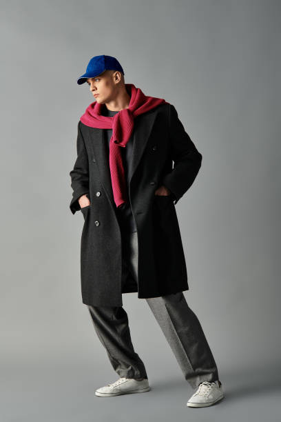istock Stylish young man poses confidently in a modern outfit against a simple backdrop 2194021023