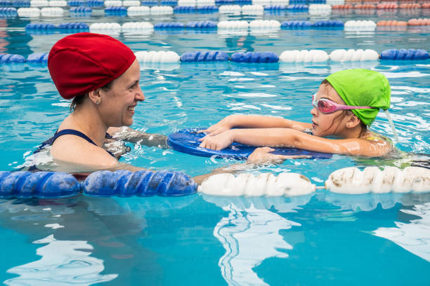 istock Teacher teaching student on a swimming pool 2194021261