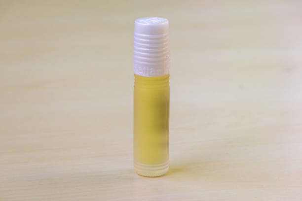 Natural perfume attar bottle kept on a wooden surface. Attar is a natural perfume made from oils extracted from various flowers, leaves, tree bark, seeds, and other plants.