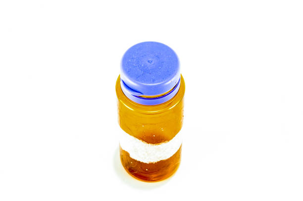 A small jar with a blue lid sits on a white background. The jar is filled with a clear liquid