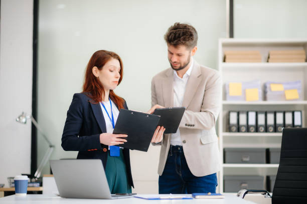 istock Two business workers talking on the smartphone and using laptop at office. 2194023572