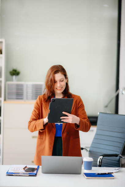 istock businesswoman working with working notepad, tablet and laptop documents talking on the smartphone, tablet 2194023580