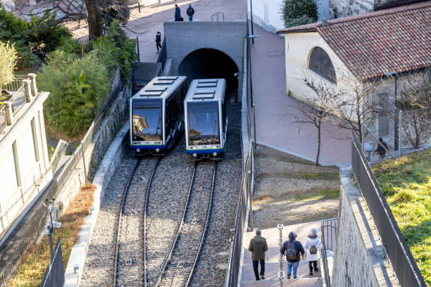 Lugano, Switzerland - Dec 24, 2024: A funicular travels alongside pedestrians on a stairway in the scenic city of Lugano