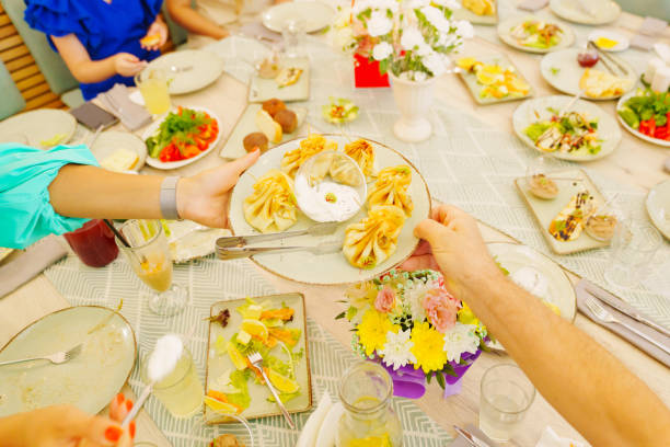 istock hands with a plate of khinkali over the served table. 2194025326
