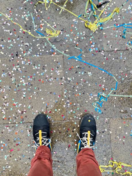 istock Person standing on wet pavement covered with confetti during Venice Carnival 2194026358