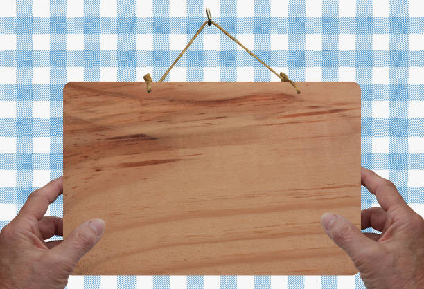 Hands hanging a blank wooden billboard