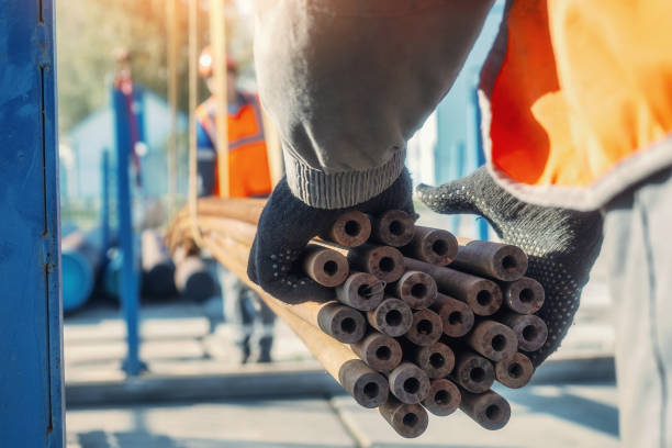 istock Construction worker handling steel pipes outdoors in sunlit environment 2194030697