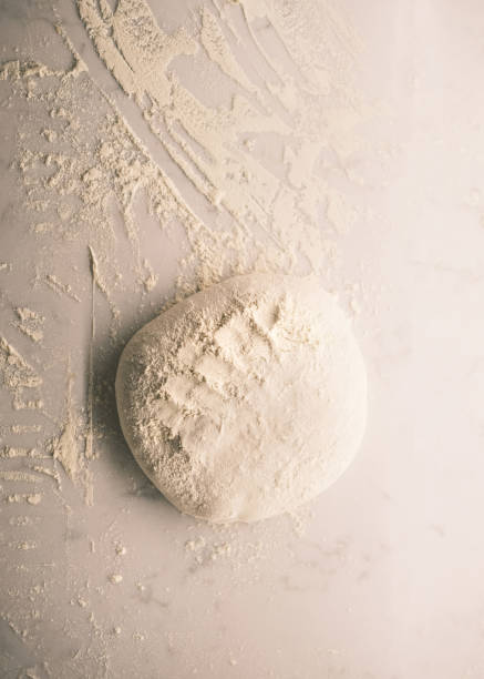 istock Freshly Prepared Pizza Dough Ball Resting on a Lightly Floured Surface in a Traditional Italian Restaurant Kitchen, Showcasing Authentic Artisanal Techniques 2194031406