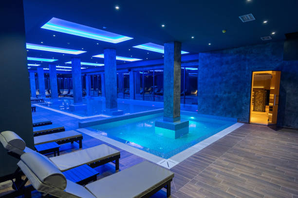 istock Modern Wellness Center Indoor Pool with Lounge Chairs and Blue Lighting 2194032388