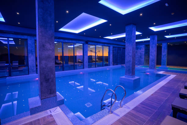 istock Modern Wellness Center Indoor Pool with Lounge Chairs and Blue Lighting 2194032395