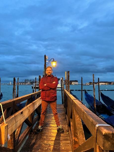 Venice, Italy, August 13, 2017: tourists walking and some others in a restaurant in Venice at nightr