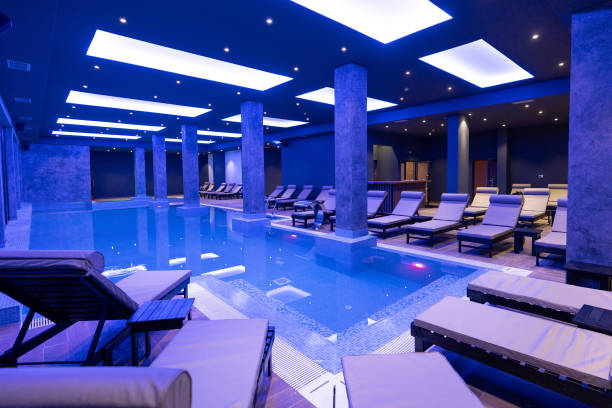 istock Modern Wellness Center Indoor Pool with Lounge Chairs and Blue Lighting 2194035501