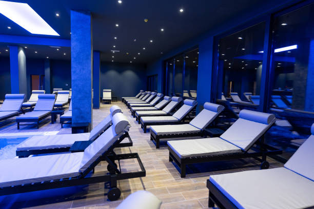 istock Modern Wellness Center Indoor Pool with Lounge Chairs and Blue Lighting 2194035524
