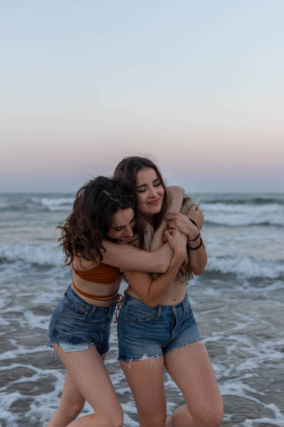 istock Happy lesbian couple embracing on beach 2194037343