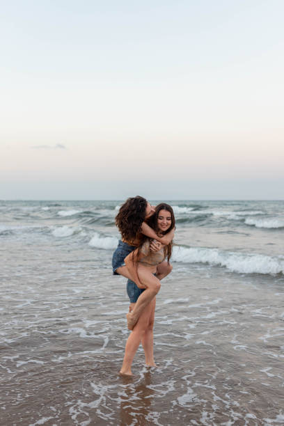 istock Lesbian couple having fun near sea 2194037352