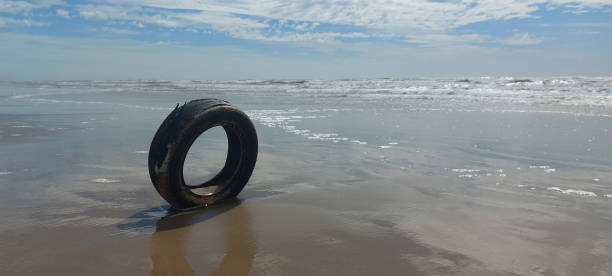 istock tire on the beach in winter 2194039718