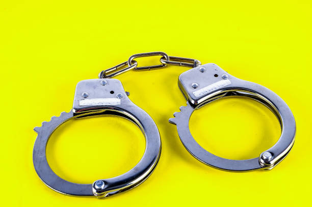 istock Two handcuffs are on a yellow background 2194043461
