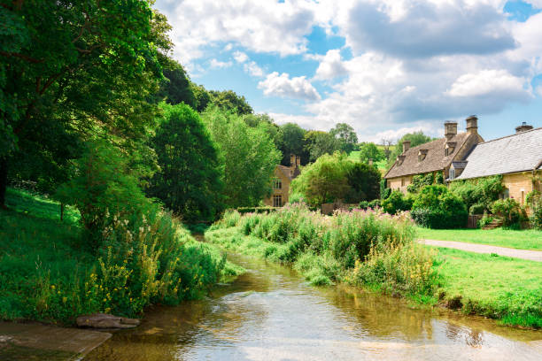 istock Scenic cotswolds village with river flowing through lush greenery under a summer sky 2194043824