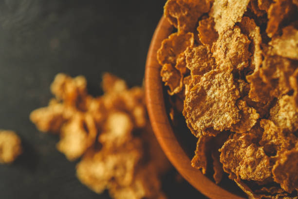 istock A wooden bowl filled with crunchy breakfast cereal flakes on a dark surface with rustic fabric in the background. Perfect for illustrating breakfast or healthy eating concepts 2194043926