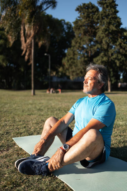 istock Man stretching outdoors during a sunny day on a green grass field 2194045199