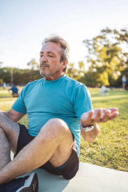 Man Practicing Meditation Outdoors in a Park During a Bright Sunny Day