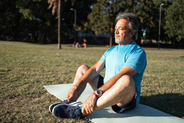 istock Man practicing yoga outdoors on a sunny day in a green park 2194045207