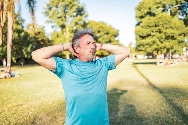 istock Middle-aged man stretching outdoors in a sunny green park setting 2194045237