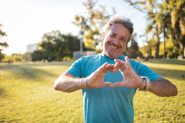 istock Smiling man forming a heart with hands in a sunny park setting 2194045306