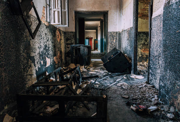 istock Abandoned corridor with charred debris, burnt walls, broken window frames, and scattered remnants inside ravaged building after catastrophic fire 2194046085