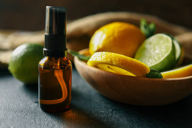 istock A dark amber essential oil bottle placed on a rustic dark surface with fresh lemons, limes, and mint leaves in the background. A natural and aromatic scene perfect for wellness and organic themes 2194046692