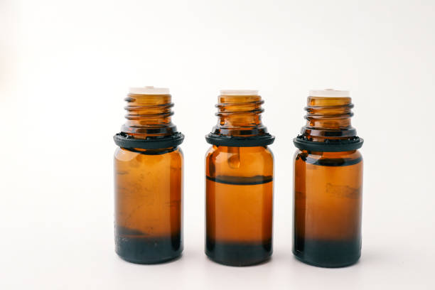 Three amber glass bottles arranged side by side on a white background. Minimalist composition emphasizes clean lines and the rich color of the bottles.