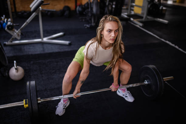 istock Athletic woman showcasing strength with barbell lift. 2194049711