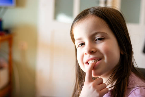 istock A little girl points her finger at a fallen tooth 2194049874