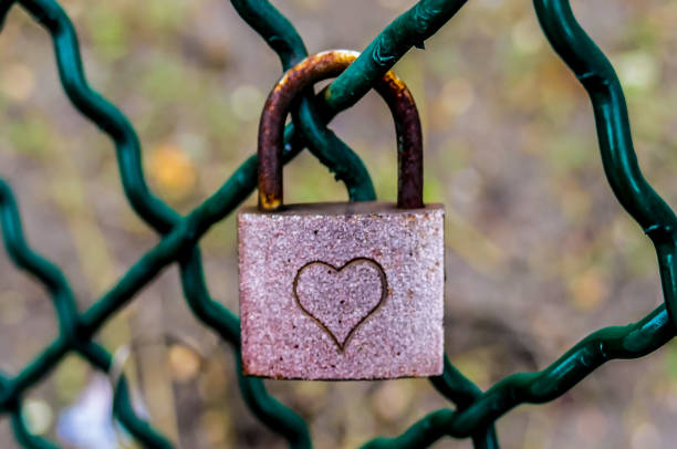 istock A rusty lock with a heart on it is hanging from a chain link fence 2194051721